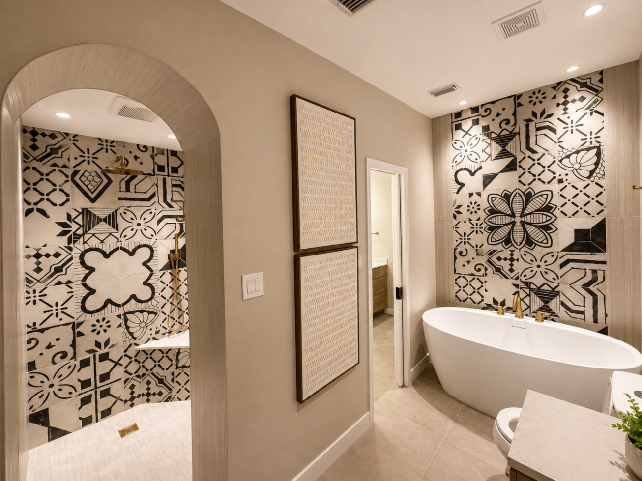Arched shower opening beside a freestanding tub with patterned tile walls and brass fixtures.