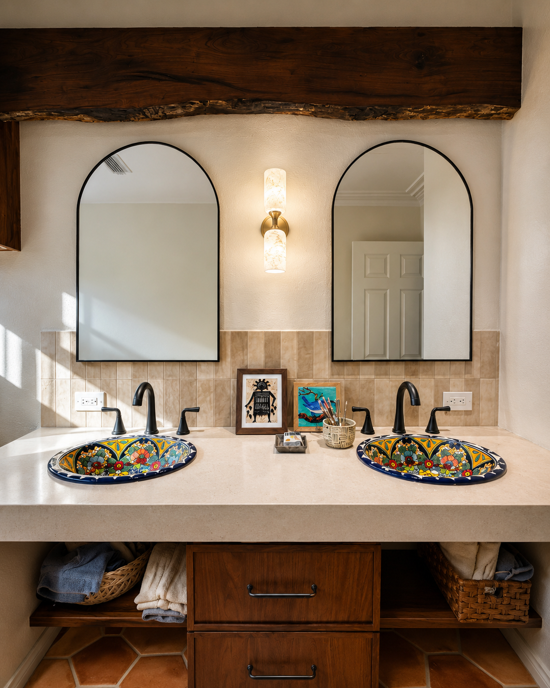 Double vanity with painted ceramic sinks, black fixtures, arched mirrors, and warm wood cabinetry.